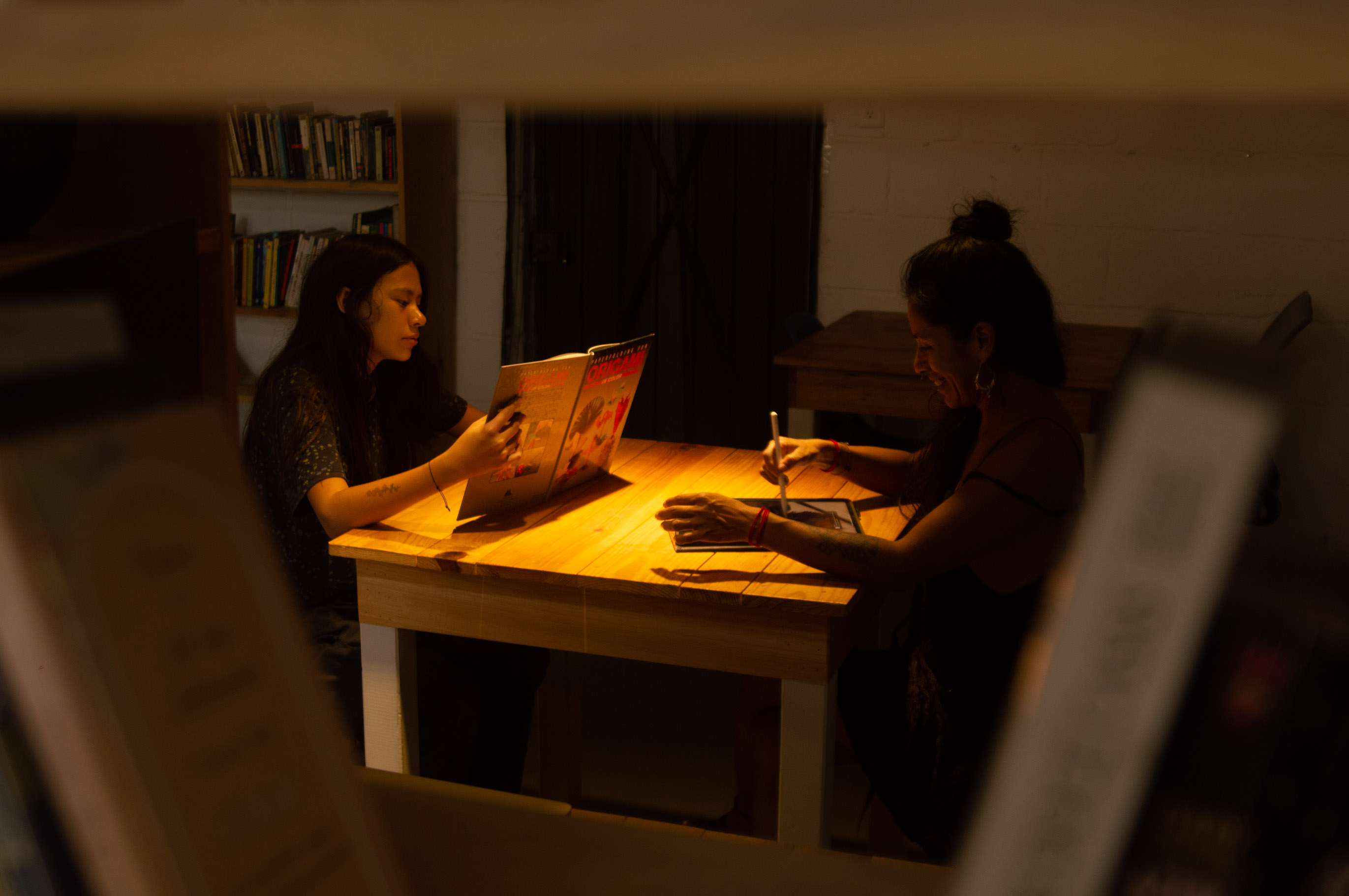 Dos personas colaborando en una mesa con ambiente cálido